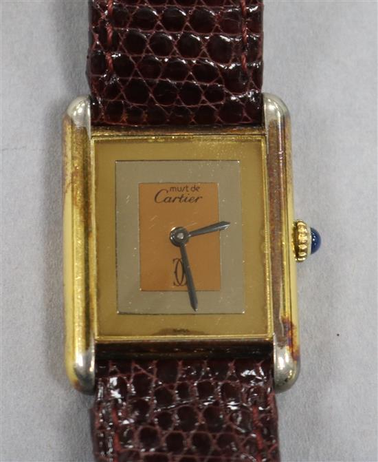 A ladys silver gilt Must de Cartier tank wrist watch, with blue cabochon winder